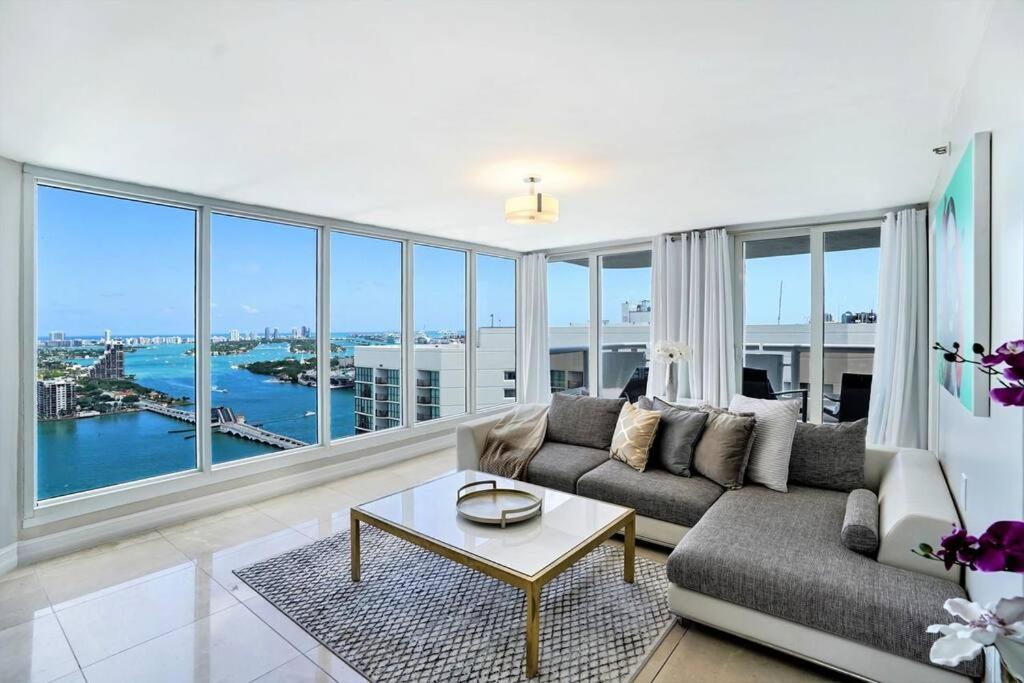 sala de estar con sofá y ventana grande en Pisces Dream - Direct water views!, en Miami
