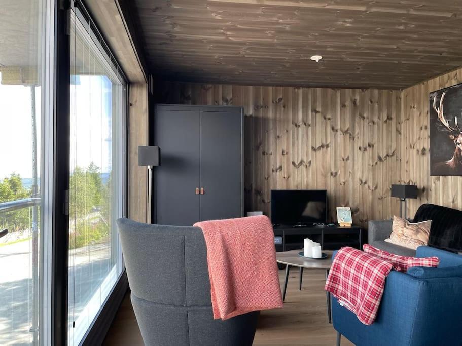 a living room with a couch and a chair at Ski in/out, amazing views, 3 bedrooms in Noresund