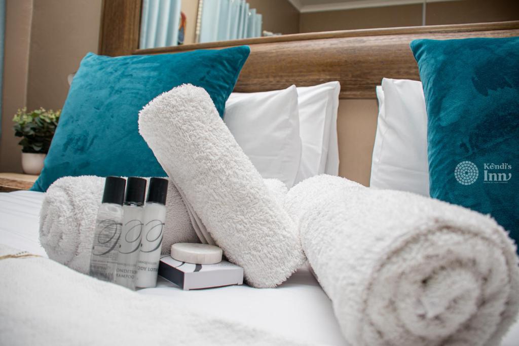 ein Bett mit weißen Handtüchern und Kissen darauf in der Unterkunft Kendi's Inn Self Catering Apartments in Jwaneng