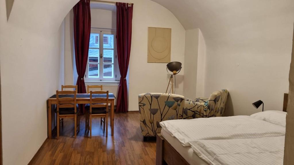 1 dormitorio con 1 cama, mesa y sillas en neVINNÉ Apartmány en Kolín