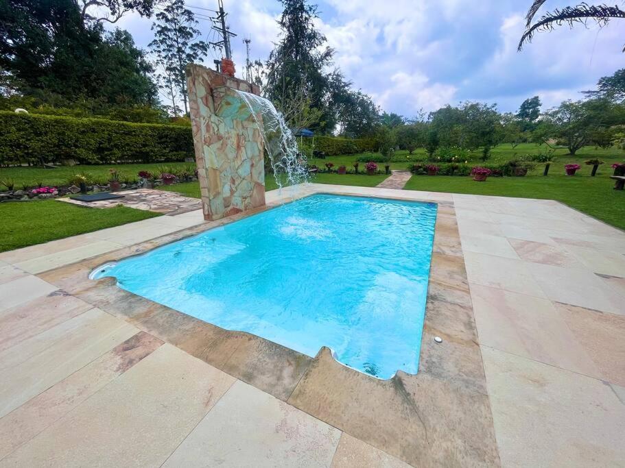 a swimming pool with a fountain in a park at Cabaña amplia con piscina, naturaleza y cercana in Los Santos