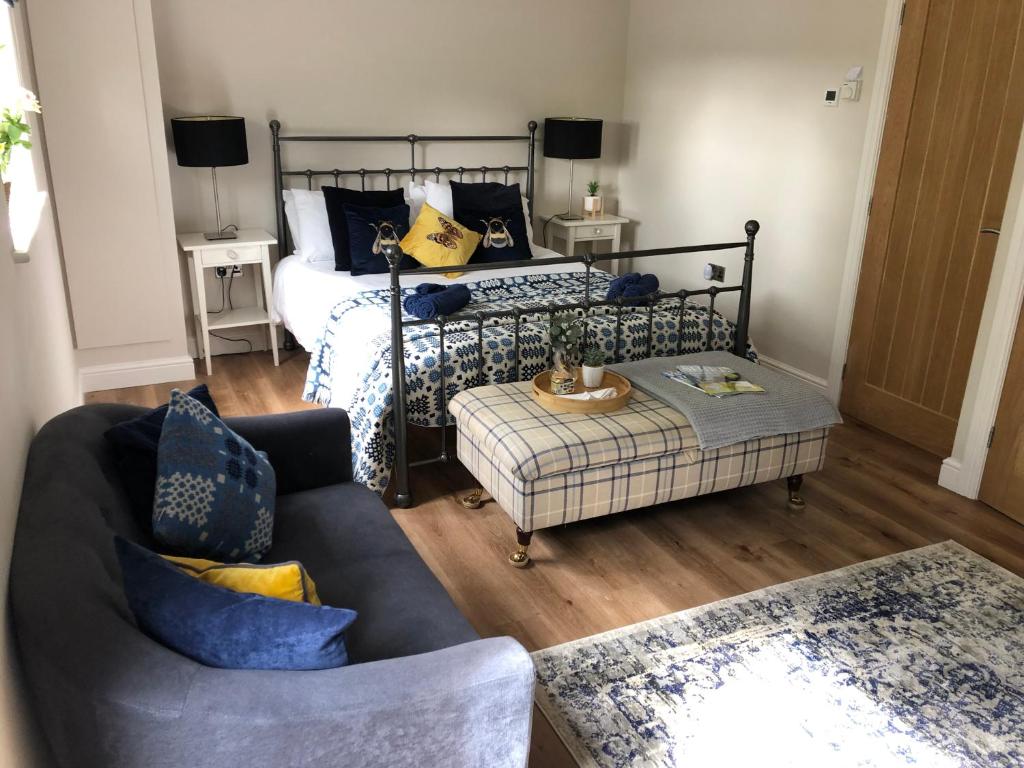 een woonkamer met een bed en een bank bij Orchard house guest studio accommodation in Marchwiel