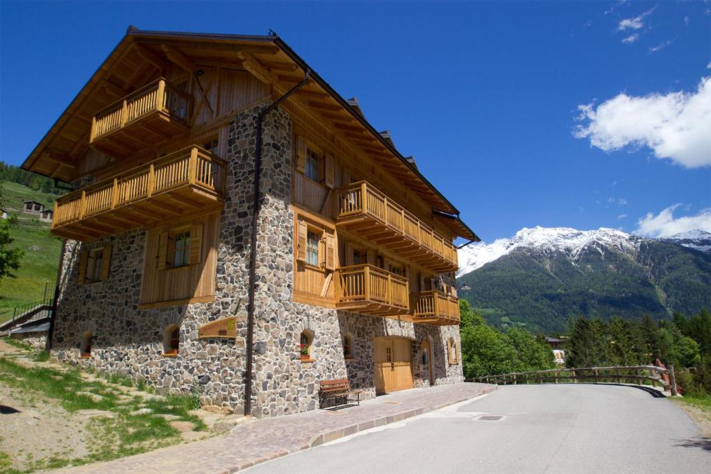 un bâtiment avec des balcons en bois sur le côté d'une route dans l'établissement Casa Marizzoni, à Peio Fonti