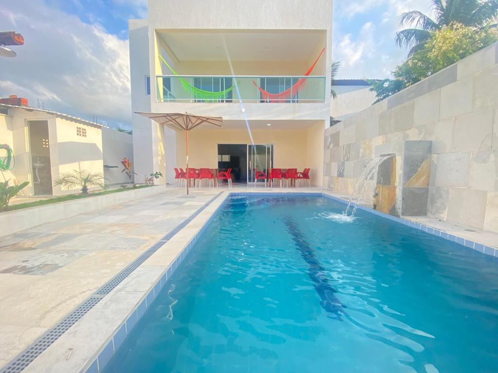 a swimming pool in the backyard of a house at Casa Deluxe 2 Maragogi in Maragogi