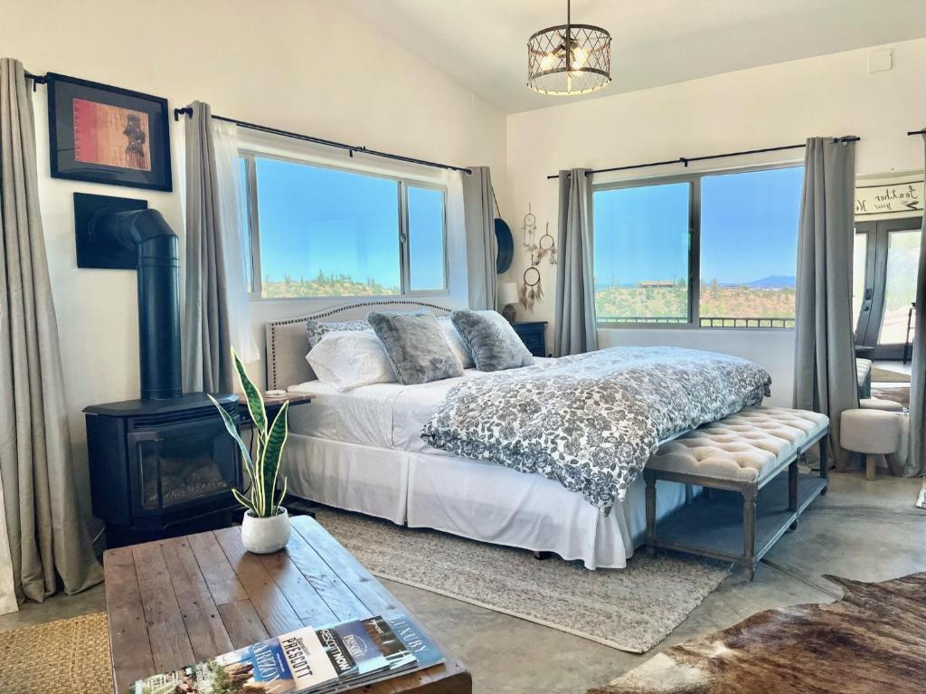 a bedroom with a bed and two large windows at NEW Feather Your Nest King bed Casita, Balcony/BBQ, Amazing views & great Location! Dog friendly in Prescott