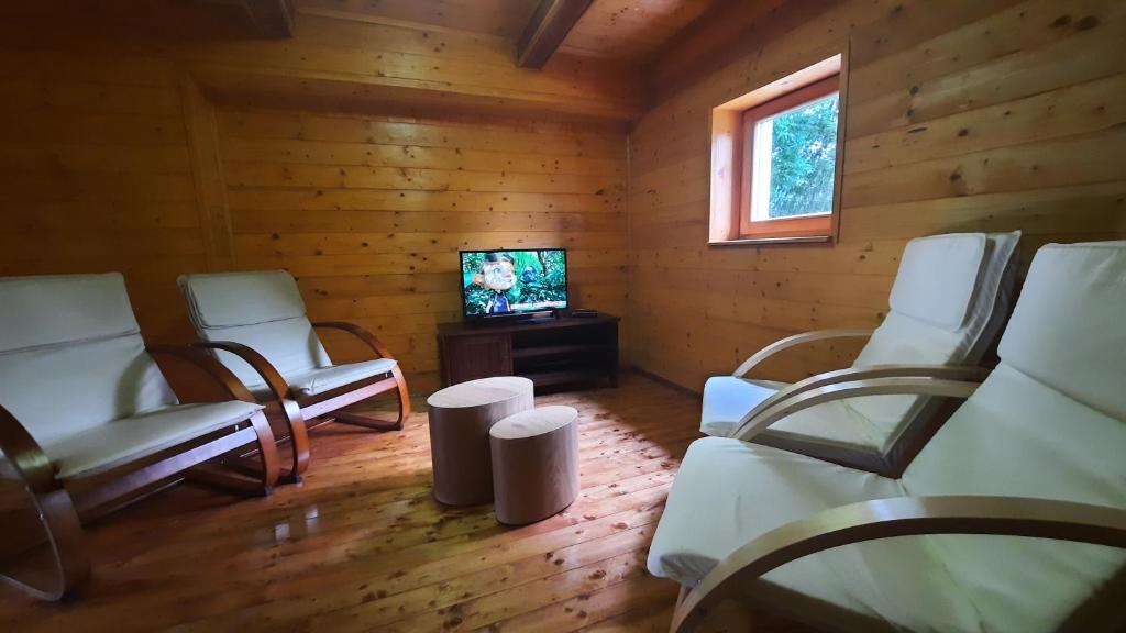 a living room with white chairs and a television at Vacation House Home, Plitvice Lakes National Park in Plitvička Jezera