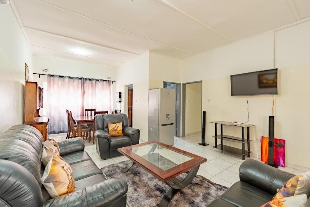 a living room with a couch and a table at Wood Road Guest Lodge in Victoria Falls