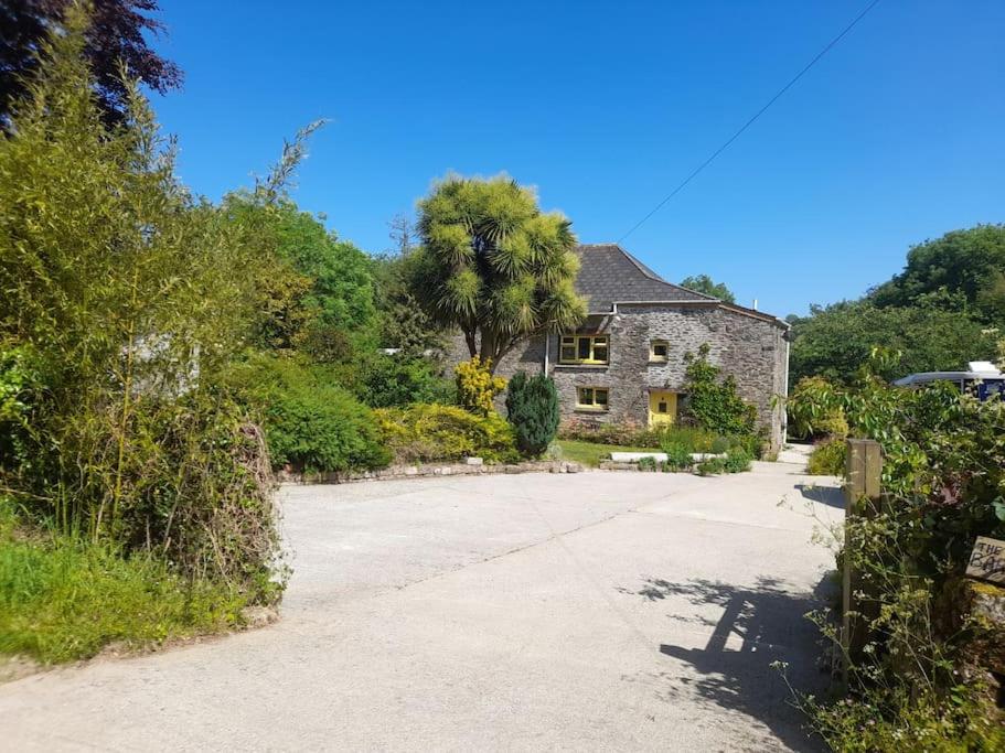 an old stone house in the middle of a driveway at The Barn in Saltash