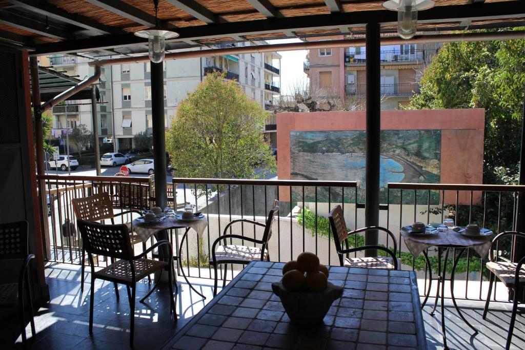 balcón con mesas y sillas y vistas a la calle en Affittacamere Delaide, en Levanto