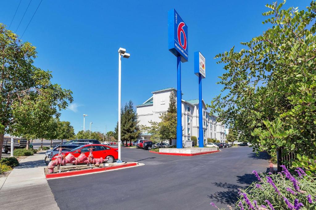 stacji benzynowej z czerwonym samochodem zaparkowanym na parkingu w obiekcie Studio 6 Belmont, CA San Francisco Redwood w mieście Belmont