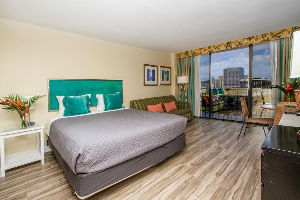 a hotel room with a bed and a balcony at Ocean view Balcony Walk to beach PW722 in Honolulu