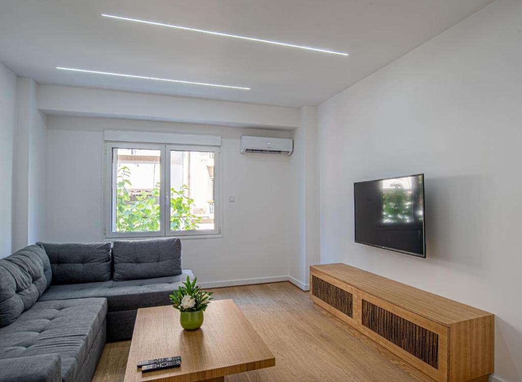 sala de estar con sofá y TV en Suitelife, en Atenas