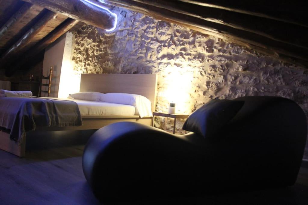 - une chambre avec 2 lits et un mur en pierre dans l'établissement Casa Rústica y vistas a la montaña - Els Llavadors, à Villafranca del Cid