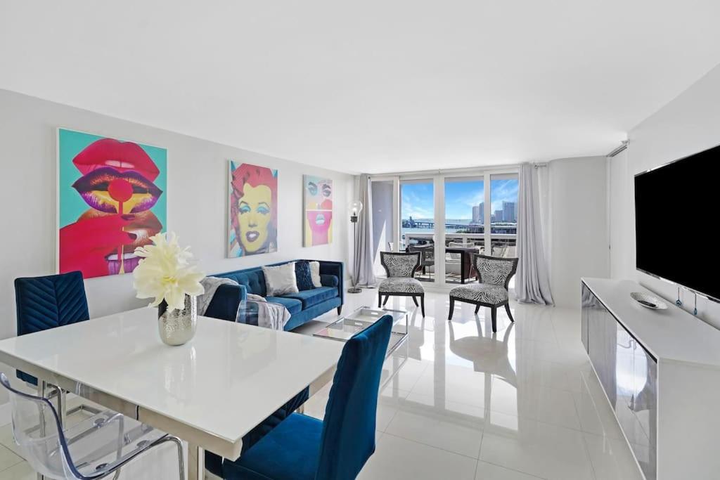 uma sala de estar com uma mesa branca e cadeiras azuis em The Marilyn! Renovated and Amazing Skyline Views! em Miami