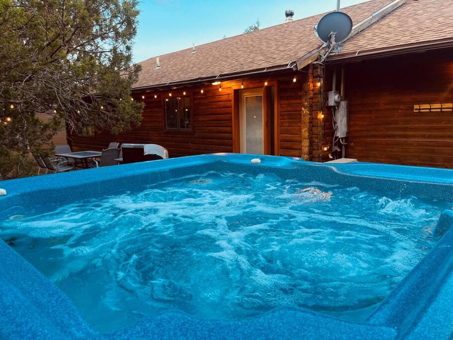 ein großer blauer Whirlpool vor einem Haus in der Unterkunft A Cozy Cabin Escape in Tijeras-Hot Tub-Game room-Pet Friendly! in Tijeras