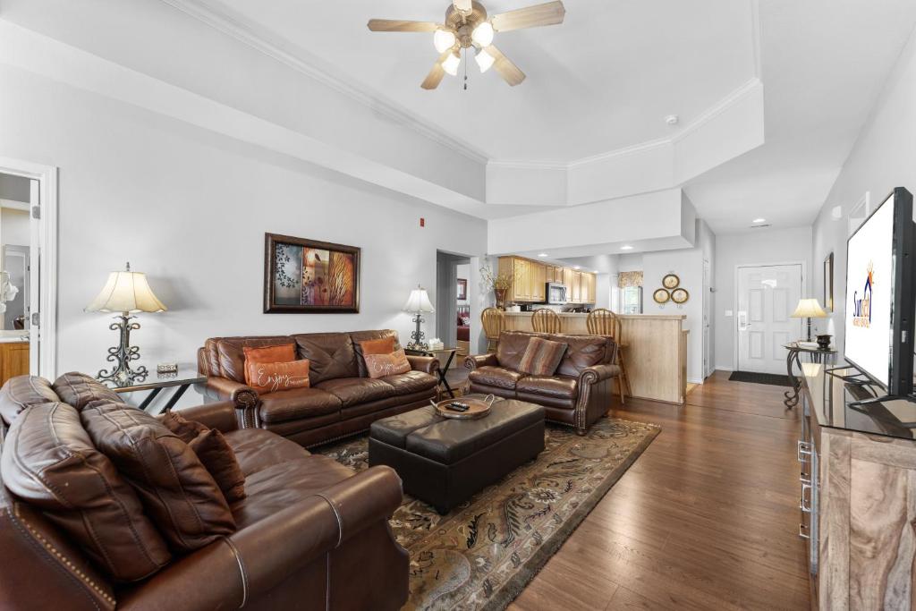 a living room with leather furniture and a ceiling fan at Green Mountain Grand Condo in Branson