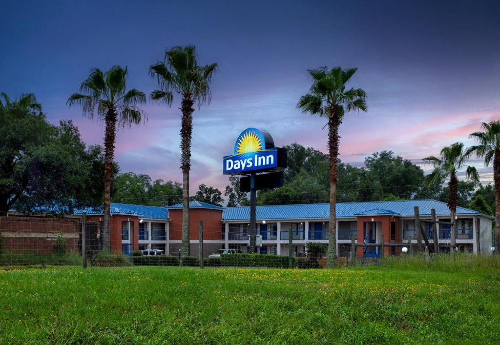 a dbs inn with palm trees in front of it at Days Inn by Wyndham Chipley in Chipley