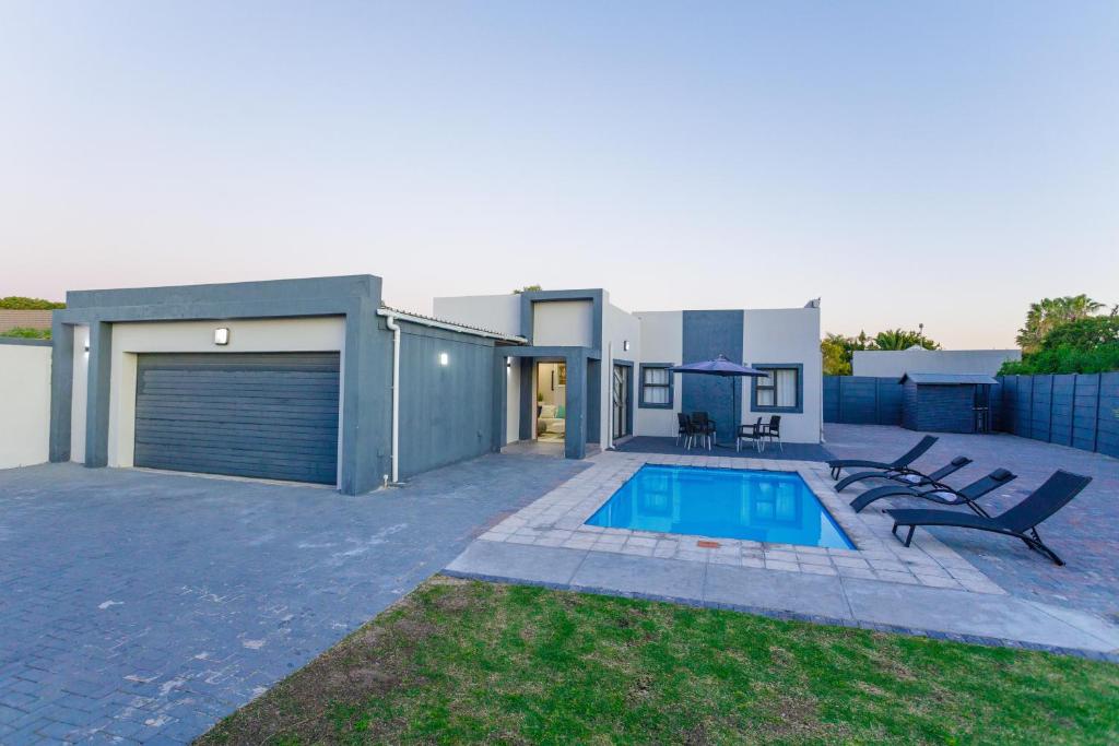 a house with a swimming pool in the backyard at Cozier Glitz in Cape Town