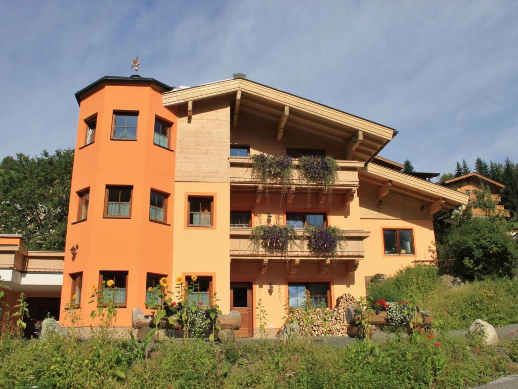 un edificio naranja con macetas. en Löhnersbach, en Saalbach Hinterglemm