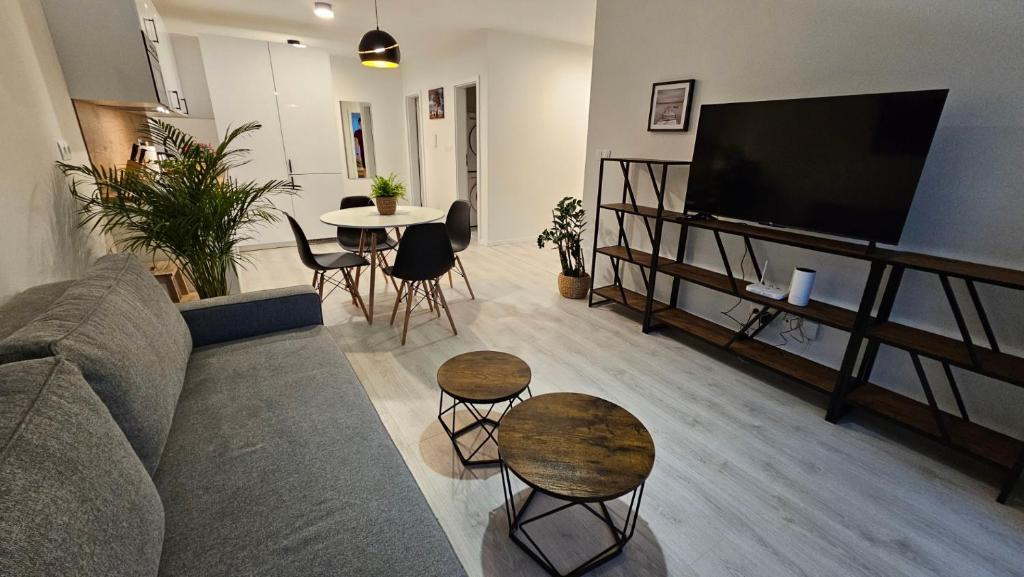 uma sala de estar com um sofá e mesas e uma televisão em 2 room Apartment with terrace, new building, 3BK em Bratislava