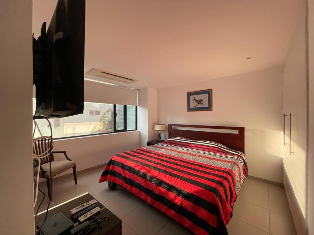 a bedroom with a bed and a television in it at Departamento en Manta Edificio Poseidon in Manta