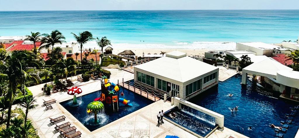 an aerial view of a resort with a swimming pool and the ocean at Solymar Beach Condos in Cancún