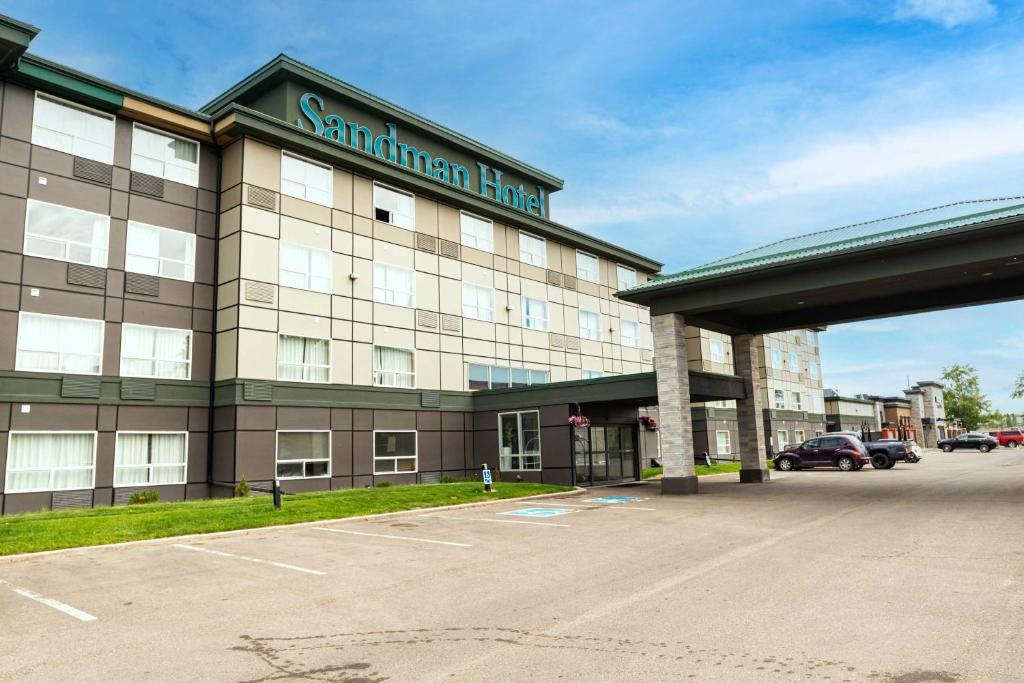 un bâtiment avec un parking en face de celui-ci dans l'établissement Sandman Hotel Red Deer, à Red Deer