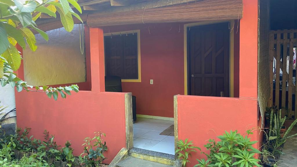 una puerta abierta de una casa de color rojo en Hospedagem Brisa e Mar en Rio do Amaro