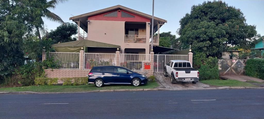 una macchina blu parcheggiata di fronte a una casa di Chands Apartment a Lautoka