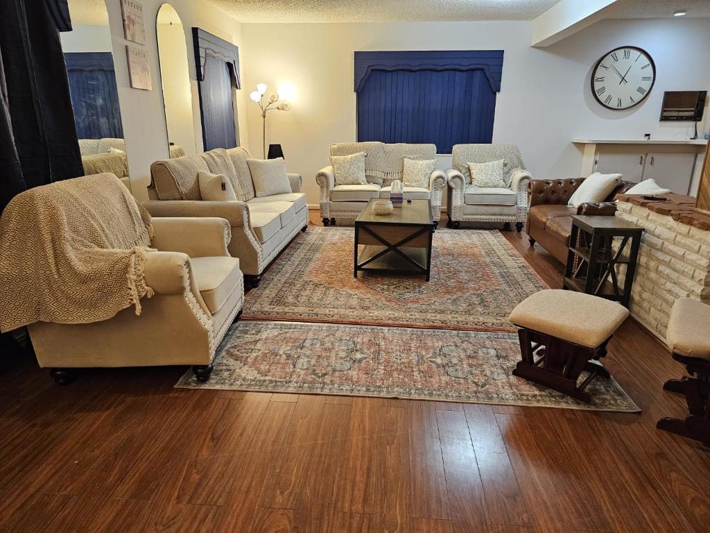 uma sala de estar com sofás e cadeiras e um relógio em The Home em Sanford