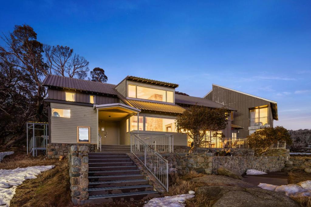 a house with a stone wall at Kooloora Lodge in Perisher Valley