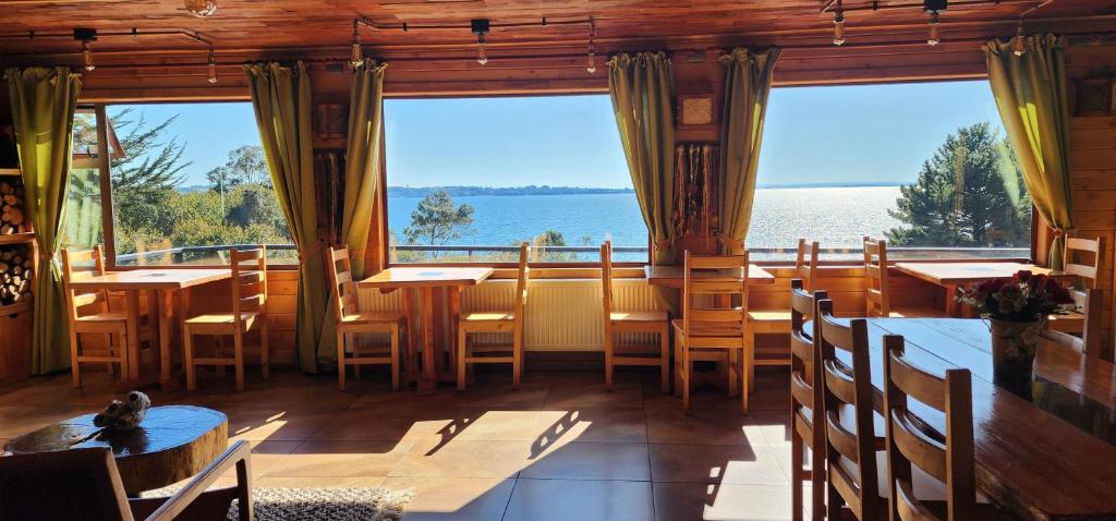 a restaurant with tables and chairs and a large window at Hotel y Cabañas Terrazas Vista al Mar hct in Ancud