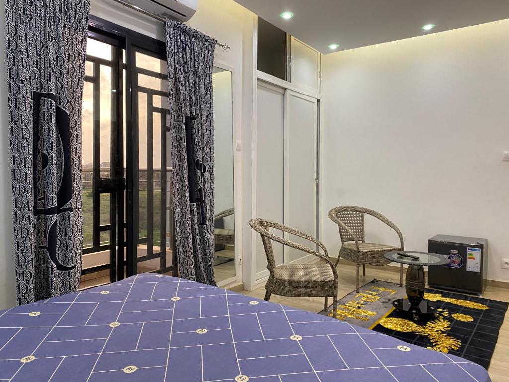 um quarto com uma cama, uma mesa e cadeiras em Résidence El Hadji Annexe em Dakar