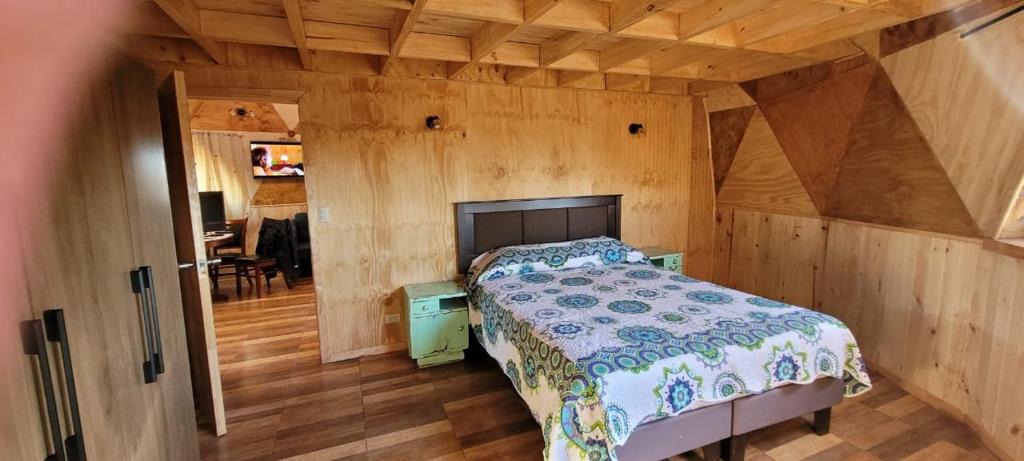 een slaapkamer met een bed in een kamer met houten wanden bij Domo Familiar Mi Espacio Rustiko in San Carlos