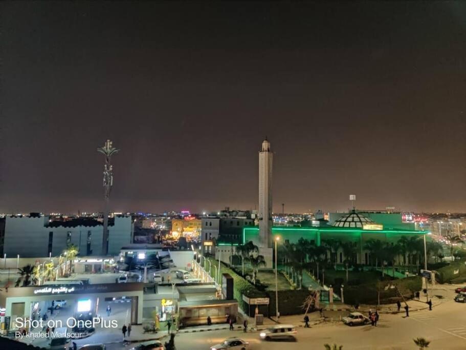 een uitzicht op een stad 's nachts met een toren bij Happy Stay® at Central New Cairo in Caïro