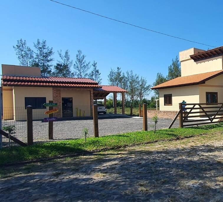 una casa con una valla y un patio de juegos delante de ella en Casa de Praia- Village Dunnas- Bal. Gaivota-SC en Balneário Gaivotas