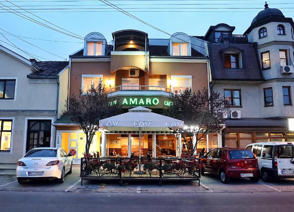 un bâtiment avec un parapluie et des voitures garées devant lui dans l'établissement Apartmani Amaro, à Novi Sad