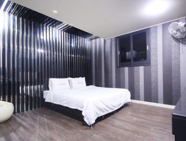 統營的住宿－VIP Motel，一间卧室配有一张床,墙上配有电视