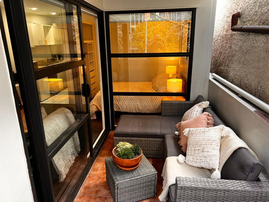 a person sitting on a couch in a tiny house at Studio Apartment in Auckland CBD in Auckland