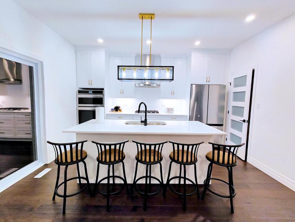 a kitchen with a island with four bar stools at Luxurious and Spacious Home in Denfield