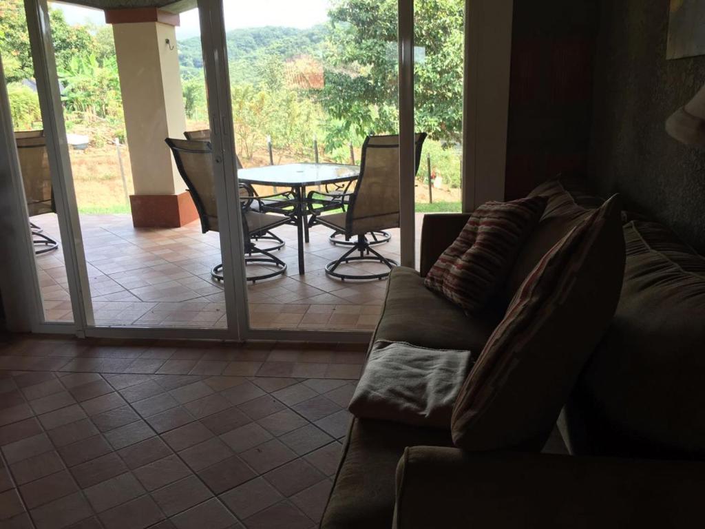 een woonkamer met een bank en een tafel en stoelen bij Boca De Los Rios River Site in Penonomé