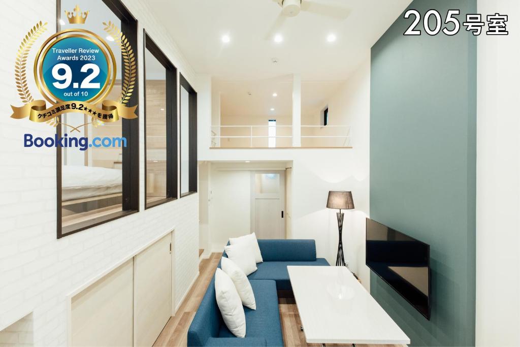ein Wohnzimmer mit einem blauen Sofa und einer Uhr in der Unterkunft YOUR ROOM 熊本駅 in Kumamoto