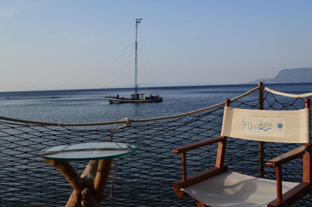 a boat in the water with a table and a chair at U Catoiu in Scilla