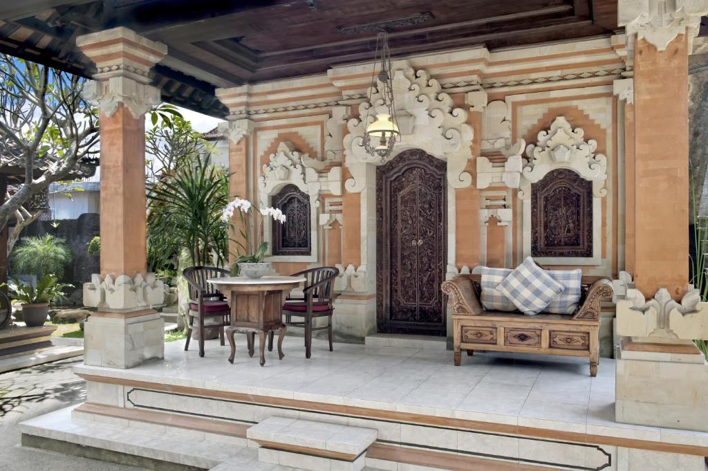 um pátio com uma mesa e cadeiras e um lustre em Teja Home Stay em Ubud