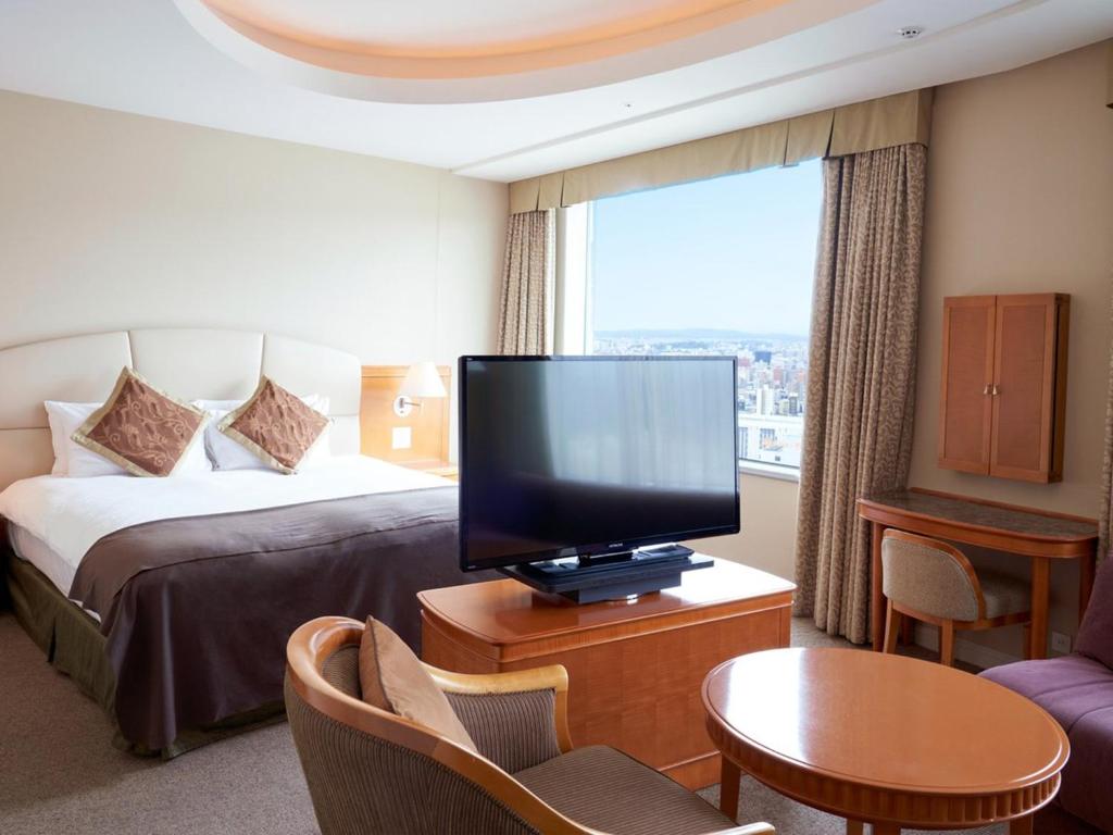 Sapporo Prince Hotel في سابورو: غرفة فندقية بسرير وتلفزيون بشاشة مسطحة