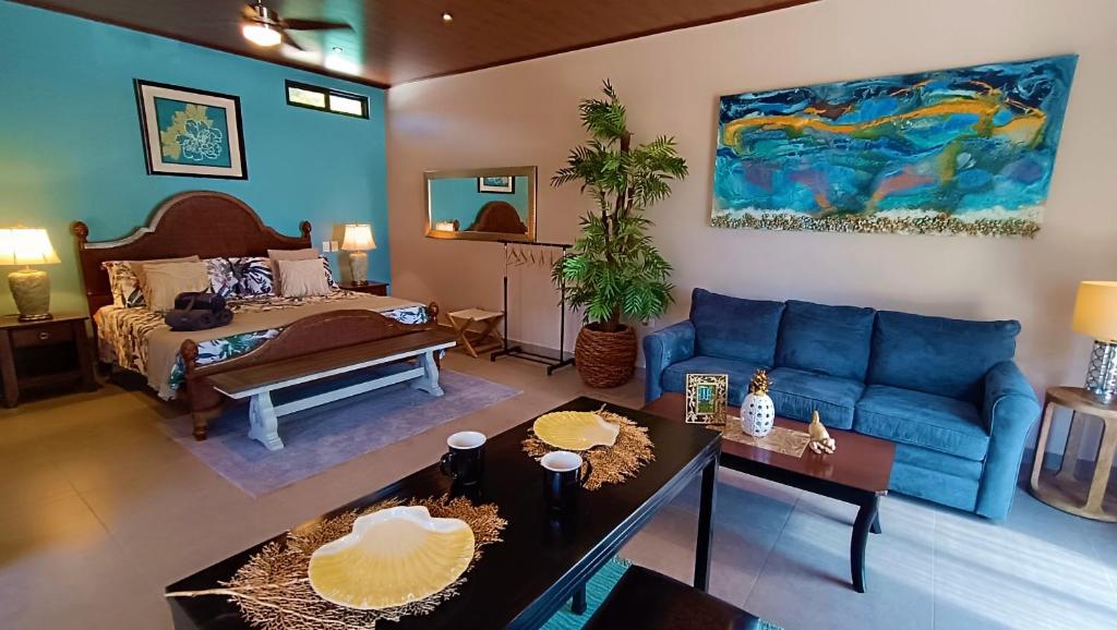 un soggiorno con divano blu e letto di Suite Dream Blue a Tamarindo