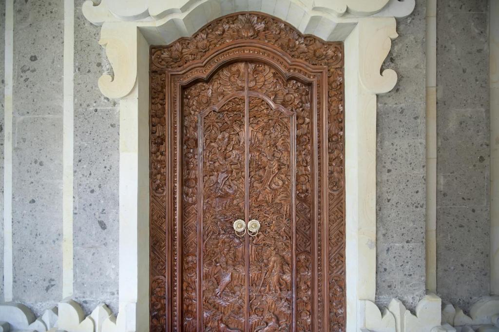 a large wooden door on a building at Teja Home Stay in Ubud