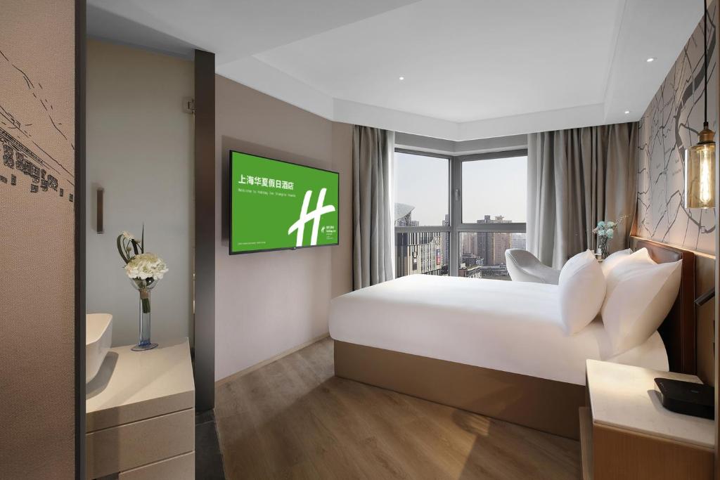 Postel nebo postele na pokoji v ubytování Holiday Inn Shanghai Huaxia by IHG - overlooking city scenery at Sky View Restaurant
