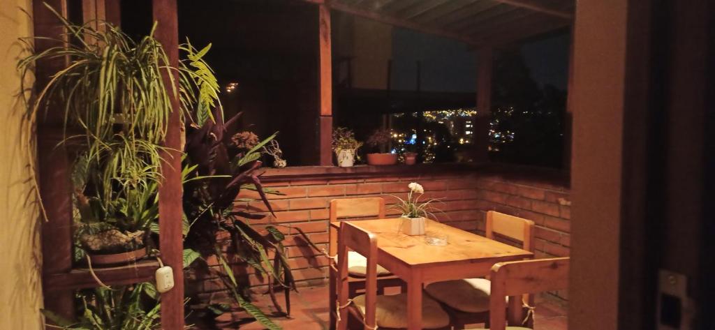 a wooden table and chairs on a patio with plants at Departamento Emily in Cuenca