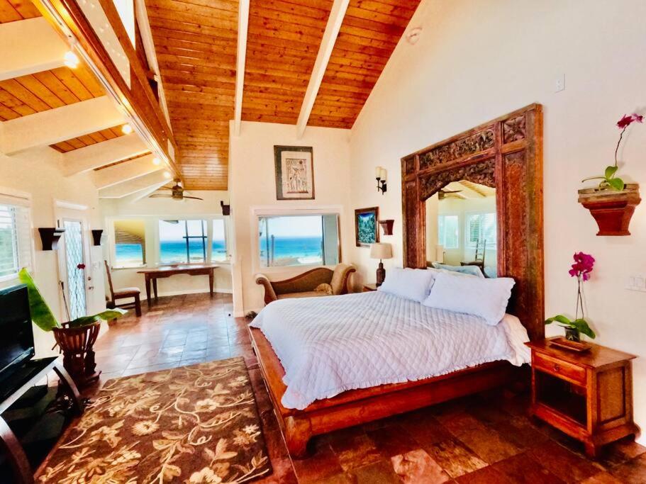 a bedroom with a bed and a living room at Private Waterfalls , Massive Big Island Estate, Ocean Views , Unbelievable Location in Hakalau